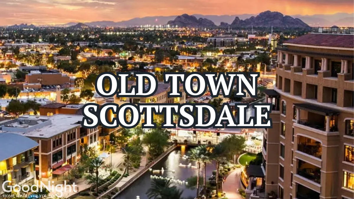 A vibrant scene showing the iconic 'Old Town Scottsdale' sign, with the waterway running alongside bustling shops and restaurants. The image also captures surrounding buildings and distant mountains, conveying the lively urban energy and walkability of the district.